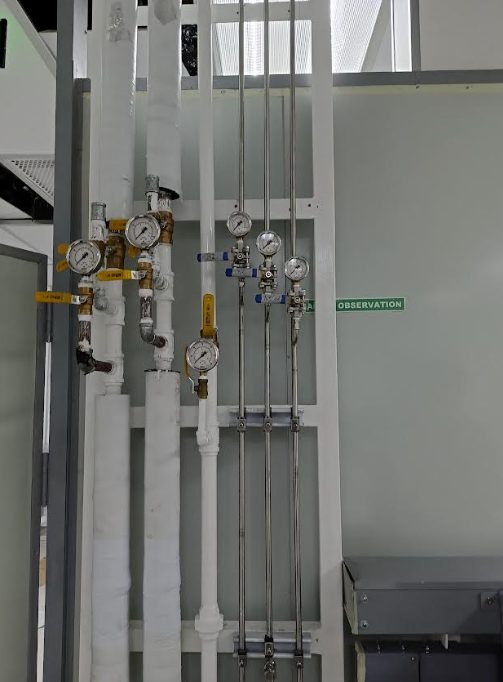 Supported stainless gas piping routed through a semiconductor cleanroom