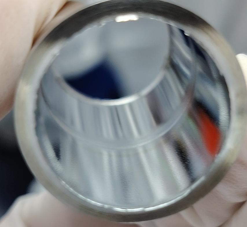 Mirror-finish interior bore of an orbital weld coupon, showing a smooth and even penetration bead
